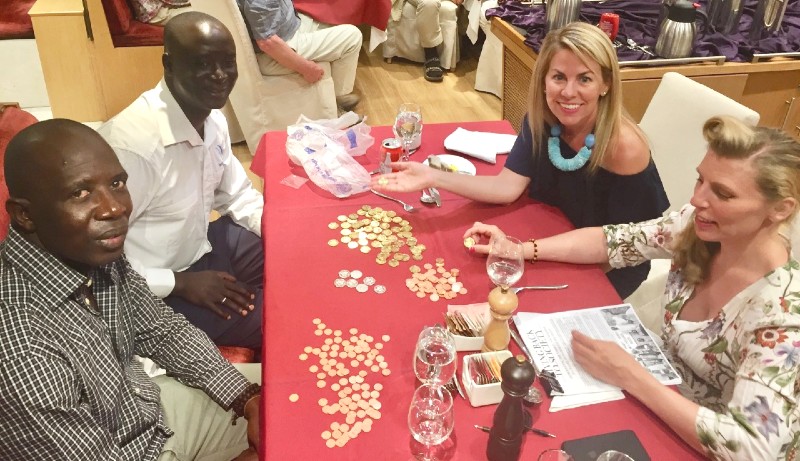 Tiffany, the Traveling Tooth Fairy, learning about money in The Gambia from local residents.